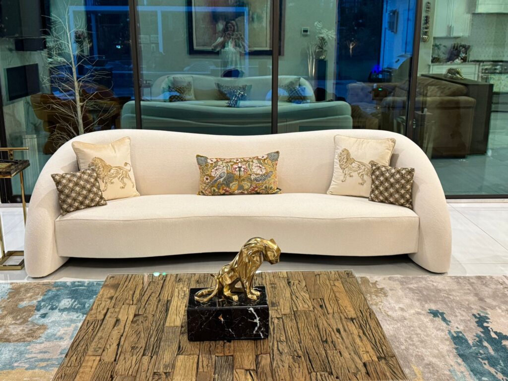 Modern luxury living room with elegant curved sofa, custom furniture, stylish decor, and premium interior design.