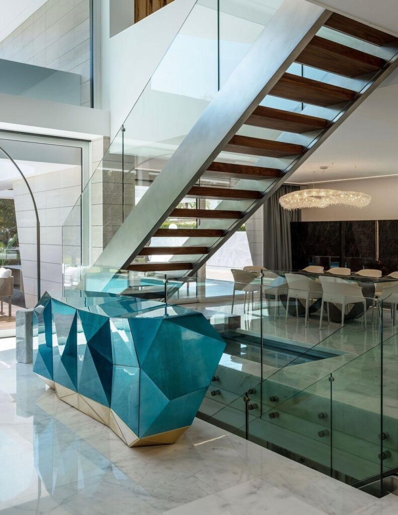 Modern luxury interior with floating staircase and glass railings.